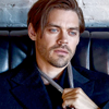 ponderosa: Tom Payne in a dark coat tugging on a thin scarf or tie around his neck (people - liev handporn)