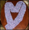 jumpuphigh: Purple scarf on table shaped like a heart. (Knit heart)