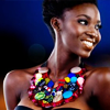 timeasmymeasure: black woman smiling widely, looking to the right; she's wearing a heavy brightly beaded necklace (stock: swag smile)