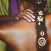 timeasmymeasure: close up of a black woman's back, her hair tied back in a long ornament-adorned brained (stock: back)